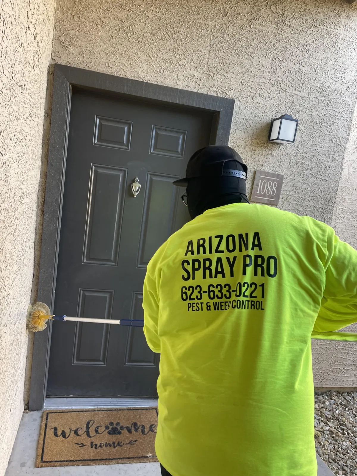 AZ Spray Pro technician servicing a residential-style unit doorway